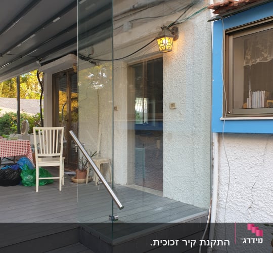 מעקה זכוכית עם ידית מתכת על מדרגות עץ